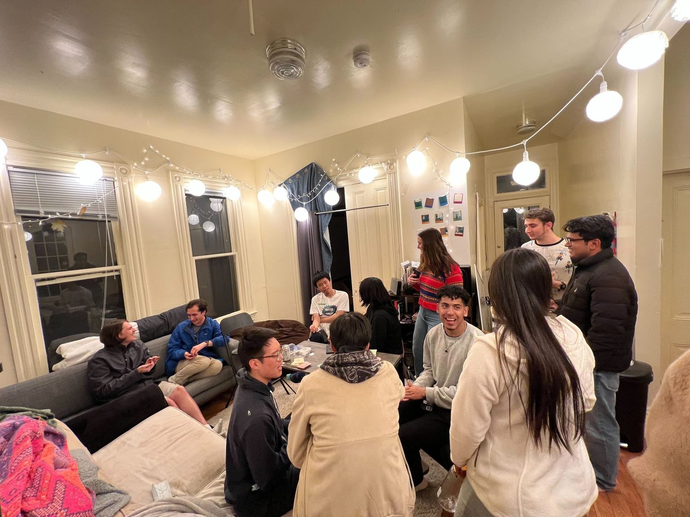Members hanging out at a string-light-lit gathering.